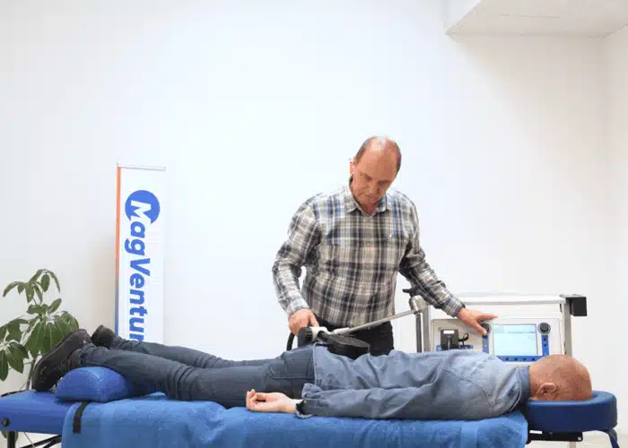 Man performing TMS therapy on patient
